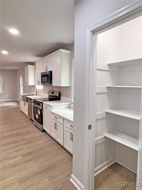 7906 Battlefield Park Rd, Henrico, VA 23231 - kitchen featuring stainless steel appliances, white cabinetry, light wood-style floors, light countertops, and recessed lighting
