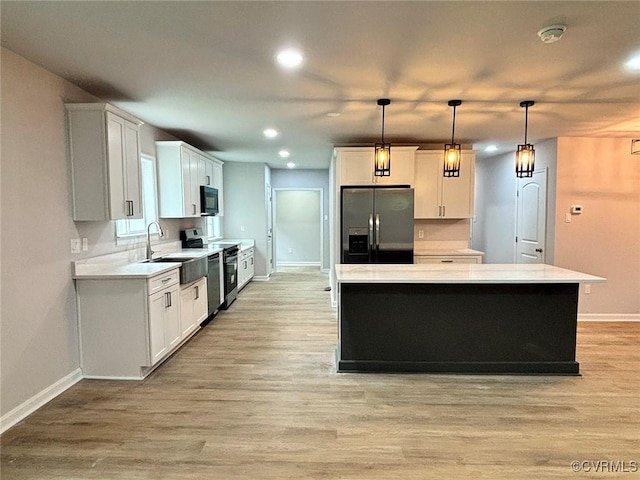 7906 Battlefield Park Rd, Henrico, VA 23231 - kitchen featuring appliances with stainless steel finishes, recessed lighting, a kitchen island, light wood-style floors, and pendant lighting