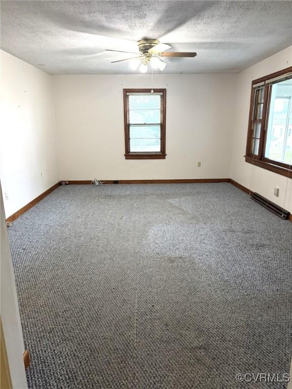5404 Oak St, North Dinwiddie, VA 23803 - carpeted spare room featuring a textured ceiling, ceiling fan, and baseboards
