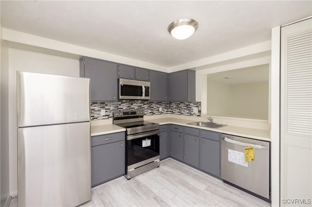 8406 Shannon Green Ct, Henrico, VA 23228 - kitchen featuring stainless steel appliances, gray cabinets, light countertops, decorative backsplash, and light wood-type flooring