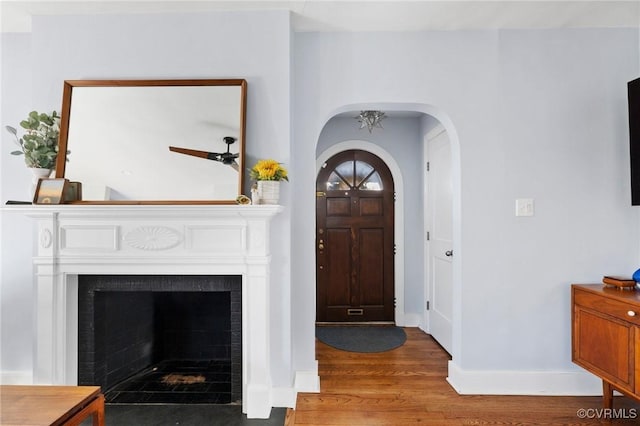 4100 Patterson Ave, Richmond, VA 23221 - foyer entrance featuring wood finished floors, arched walkways, a tiled fireplace, and ceiling fan