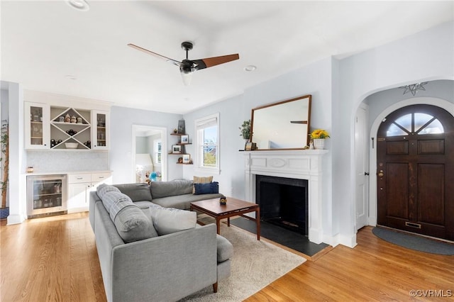 4100 Patterson Ave, Richmond, VA 23221 - living area with a dry bar, wine cooler, light wood finished floors, a fireplace, and arched walkways