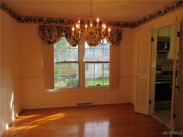 2803 Cannon Rd, Glen Allen, VA 23060 - unfurnished dining area featuring a chandelier, wood finished floors, and a textured ceiling
