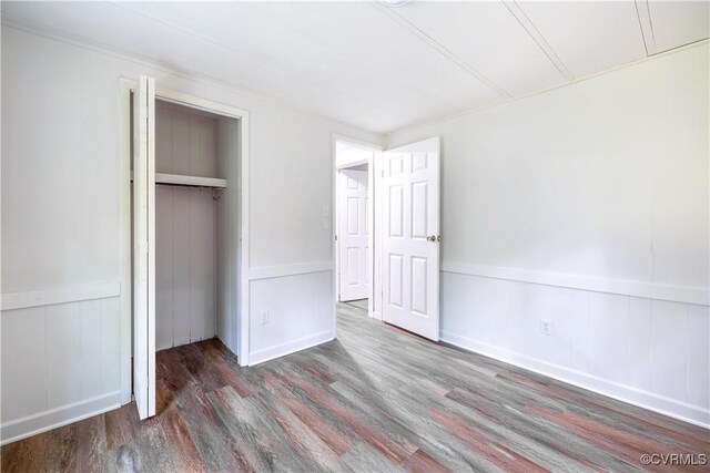 31 Pleasant Run, Cartersville, VA 23027 - unfurnished bedroom featuring wood finished floors, a closet, wainscoting, and a decorative wall