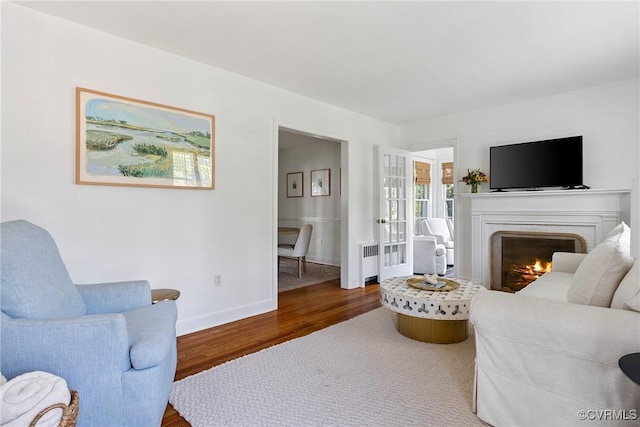 6502 W Franklin St, Henrico, VA 23226 - living area with radiator heating unit, wood finished floors, a fireplace, and french doors
