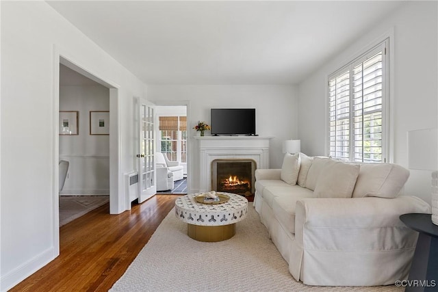 6502 W Franklin St, Henrico, VA 23226 - living area with dark wood-type flooring, radiator, and a warm lit fireplace