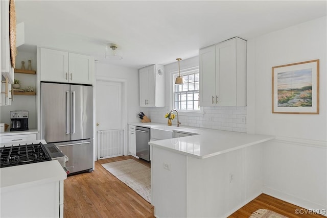 6502 W Franklin St, Henrico, VA 23226 - kitchen featuring stainless steel appliances, decorative backsplash, a peninsula, and white cabinetry