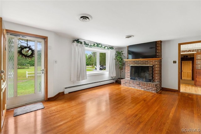 12418 Gravelbrook Rd, South Prince George, VA 23805 - unfurnished living room with a baseboard radiator, wood finished floors, and a fireplace