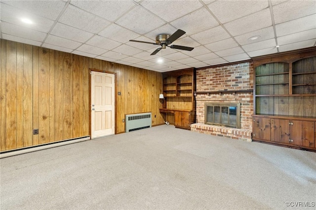 12418 Gravelbrook Rd, South Prince George, VA 23805 - unfurnished living room with radiator, a baseboard heating unit, wood walls, carpet floors, and a fireplace