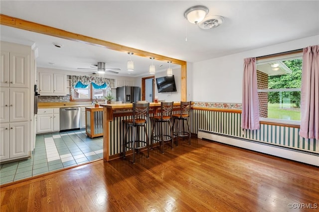 12418 Gravelbrook Rd, South Prince George, VA 23805 - kitchen with dishwasher, fridge with ice dispenser, white cabinetry, a kitchen bar, and wood finished floors