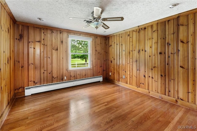 12418 Gravelbrook Rd, South Prince George, VA 23805 - spare room featuring a baseboard radiator, wood finished floors, ceiling fan, wood walls, and a textured ceiling