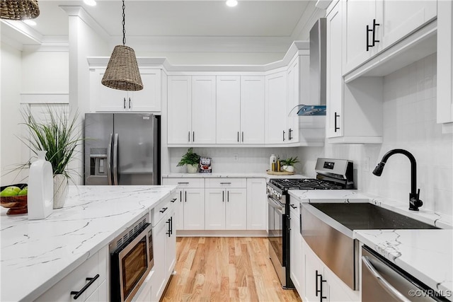 11 W 29th St, Richmond, VA 23225 - kitchen featuring appliances with stainless steel finishes, crown molding, wall chimney exhaust hood, light wood-style flooring, and tasteful backsplash