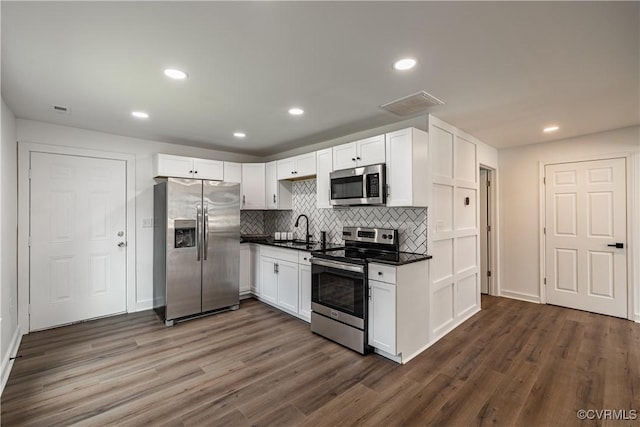 833 Wilcox St, Petersburg, VA 23803 - kitchen featuring appliances with stainless steel finishes, dark countertops, white cabinets, tasteful backsplash, and recessed lighting