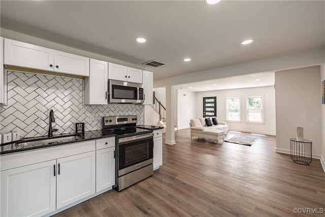 833 Wilcox St, Petersburg, VA 23803 - kitchen featuring stainless steel appliances, open floor plan, dark countertops, decorative backsplash, and white cabinets