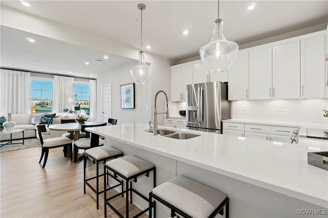 13210 Garland Ln, Midlothian, VA 23114 - kitchen with stainless steel fridge, white cabinetry, recessed lighting, light wood-style flooring, and a kitchen breakfast bar
