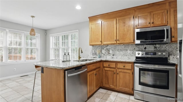 500 Village Gate Dr, Midlothian, VA 23114 - kitchen featuring appliances with stainless steel finishes, decorative backsplash, light tile patterned floors, a peninsula, and brown cabinetry