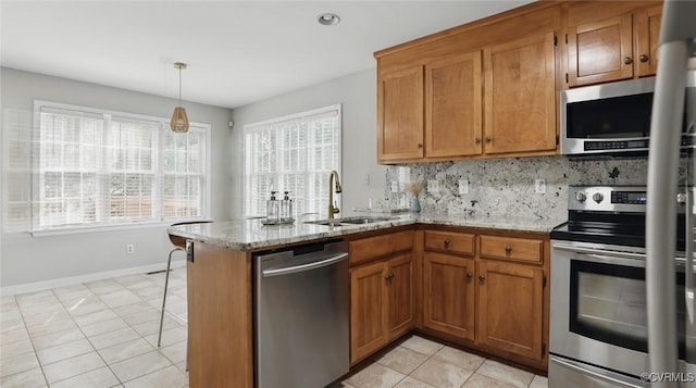 500 Village Gate Dr, Midlothian, VA 23114 - kitchen with appliances with stainless steel finishes, brown cabinets, light tile patterned flooring, decorative backsplash, and a peninsula