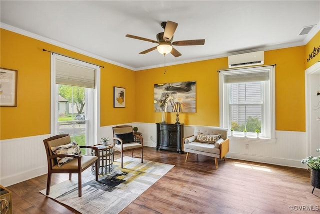 429 4th St, West Point, VA 23181 - living area featuring a wall mounted AC, wainscoting, ceiling fan, ornamental molding, and wood finished floors