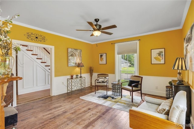 429 4th St, West Point, VA 23181 - living area with a ceiling fan, crown molding, wood finished floors, stairs, and a wainscoted wall