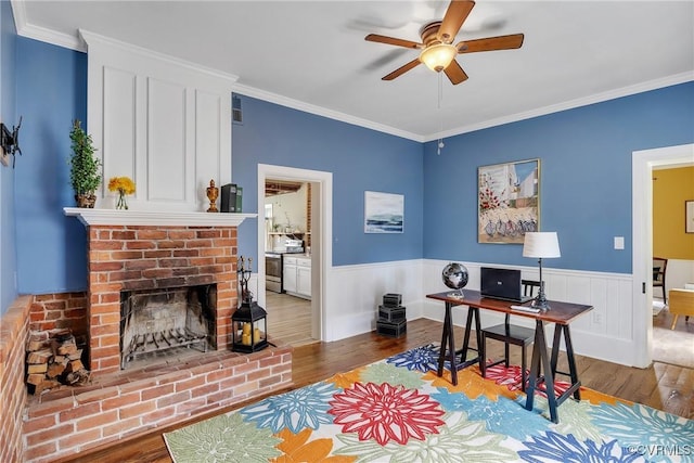 429 4th St, West Point, VA 23181 - office area featuring wood finished floors, a ceiling fan, wainscoting, crown molding, and a fireplace
