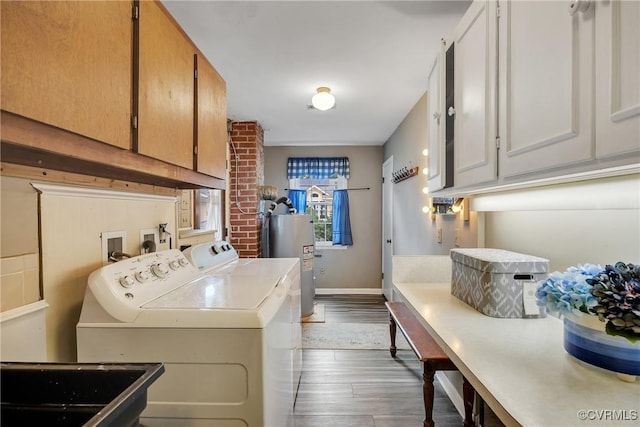 429 4th St, West Point, VA 23181 - washroom with cabinet space, electric water heater, washing machine and clothes dryer, and dark wood-style floors