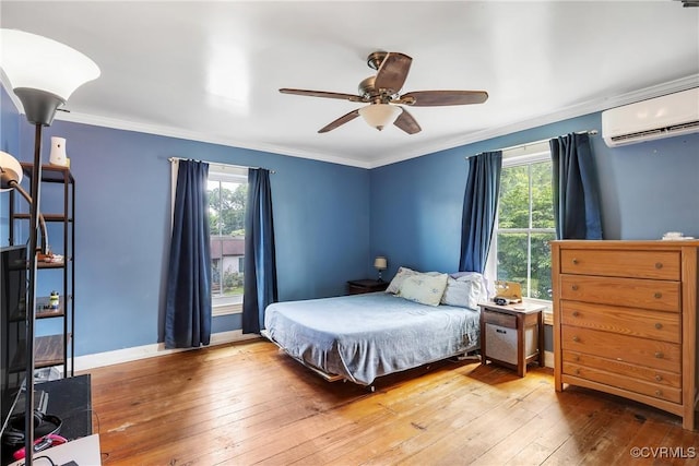 429 4th St, West Point, VA 23181 - bedroom featuring a wall unit AC, multiple windows, hardwood / wood-style floors, ornamental molding, and a ceiling fan