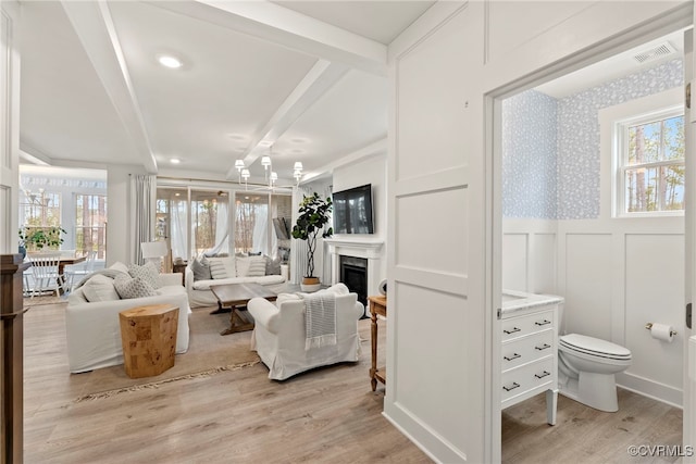 18207 Maple Summit Ct, Moseley, VA 23120 - living area with plenty of natural light, light wood-style floors, a fireplace, a decorative wall, and wainscoting