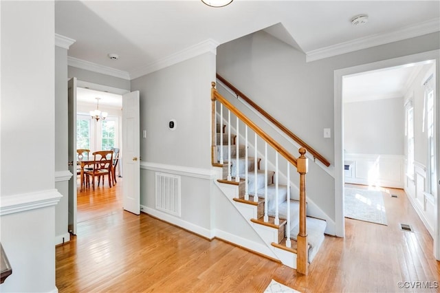 11905 Glen Gary Ct, Henrico, VA 23233 - staircase with a chandelier, wood finished floors, crown molding, a decorative wall, and a wainscoted wall