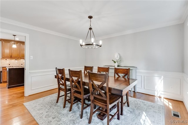 11905 Glen Gary Ct, Henrico, VA 23233 - dining room with a chandelier, light wood finished floors, crown molding, and a wainscoted wall
