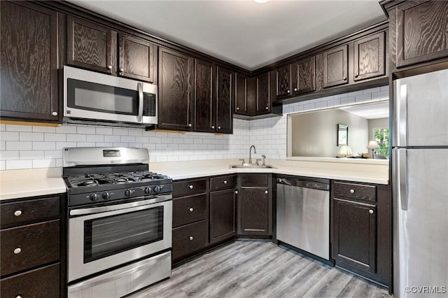 10152 Iron Mill Rd, North Chesterfield, VA 23235 - kitchen featuring stainless steel appliances, dark brown cabinetry, backsplash, light wood-type flooring, and light countertops