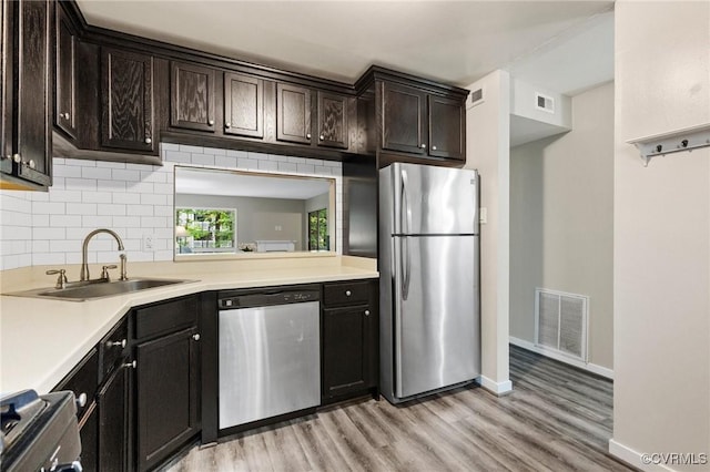 10152 Iron Mill Rd, North Chesterfield, VA 23235 - kitchen featuring stainless steel appliances, light wood-style floors, decorative backsplash, and light countertops