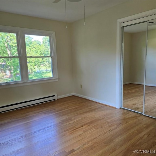 14300 Rosebud Rd, Chesterfield, VA 23838 - unfurnished bedroom featuring wood finished floors, a closet, and a baseboard radiator