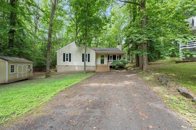 12707 Southwick Pl, Midlothian, VA 23113 - view of front of property with a chimney, asphalt driveway, a shed, covered porch, and view of scattered trees