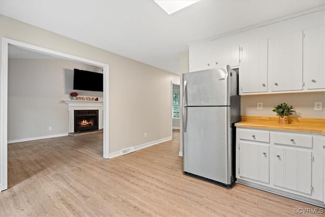 12707 Southwick Pl, Midlothian, VA 23113 - kitchen with freestanding refrigerator, light wood-type flooring, light countertops, and white cabinets