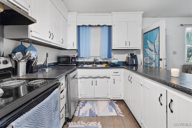 2560 Pin Oak Ct, Colonial Heights, VA 23834 - kitchen with stainless steel appliances, under cabinet range hood, wood finished floors, dark countertops, and white cabinetry