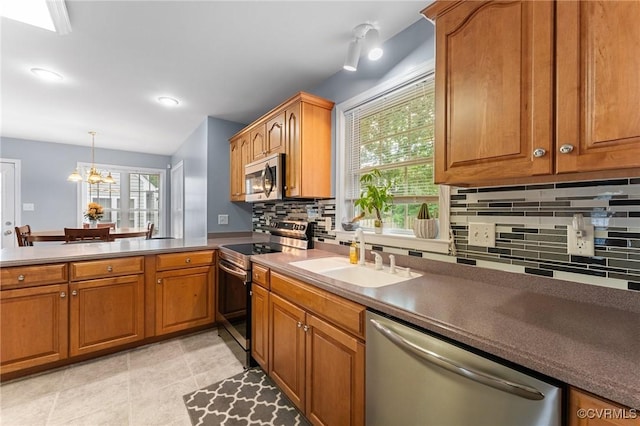 15619 Winding Ash Dr, Chesterfield, VA 23832 - kitchen with stainless steel appliances, decorative backsplash, brown cabinets, a chandelier, and decorative light fixtures