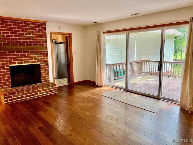 8426 Forge Rd, Henrico, VA 23228 - unfurnished living room featuring hardwood / wood-style flooring and a brick fireplace