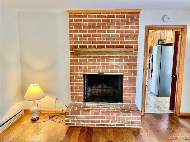 8426 Forge Rd, Henrico, VA 23228 - detailed view of baseboard heating, stainless steel fridge with ice dispenser, wood finished floors, a brick fireplace, and a smoke detector