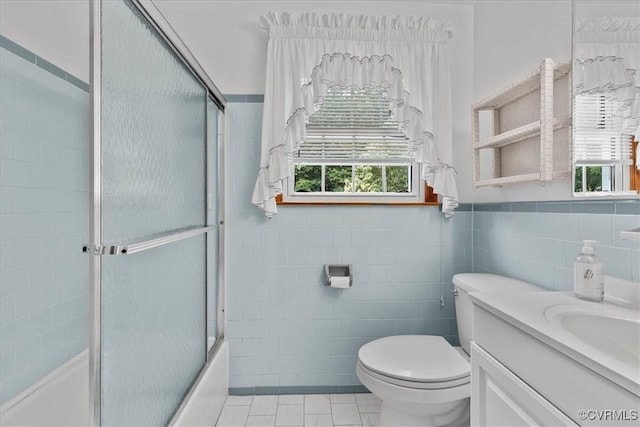 708 Compton Rd, Colonial Heights, VA 23834 - bathroom with tile walls, healthy amount of natural light, tile patterned flooring, vanity, and bath / shower combo with glass door