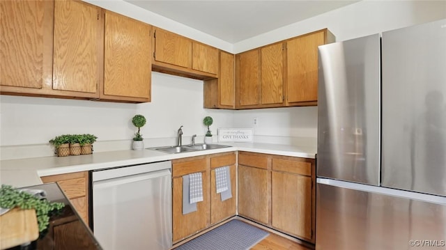 831 Winnetka Ave, Henrico, VA 23227 - kitchen with freestanding refrigerator, dishwashing machine, light countertops, brown cabinets, and light wood finished floors