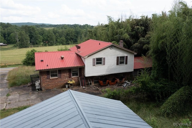 549 Ararat Hwy, Patrick Springs, VA 24053 - back of property with a metal roof, brick siding, and a view of trees