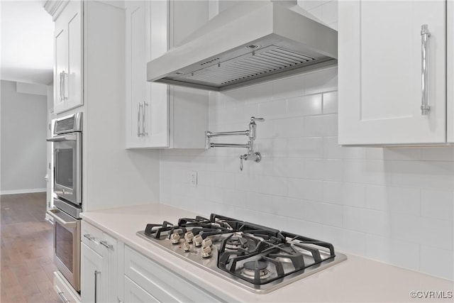 9563 Plateau Pl, Mechanicsville, VA 23116 - kitchen with ventilation hood, stainless steel appliances, white cabinetry, light countertops, and tasteful backsplash