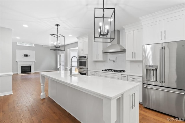 9563 Plateau Pl, Mechanicsville, VA 23116 - kitchen featuring appliances with stainless steel finishes, wall chimney exhaust hood, a chandelier, white cabinets, and recessed lighting