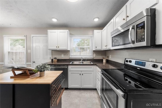410 Airycrest Dr, Highland Springs, VA 23075 - kitchen featuring appliances with stainless steel finishes, wooden counters, white cabinetry, and a textured ceiling