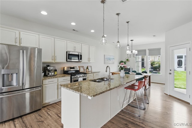 8045 Ellendale Dr, Mechanicsville, VA 23116 - kitchen featuring stainless steel appliances, light wood-style flooring, a breakfast bar area, backsplash, and white cabinets