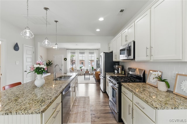 8045 Ellendale Dr, Mechanicsville, VA 23116 - kitchen with stainless steel appliances, white cabinets, a center island with sink, decorative backsplash, and recessed lighting