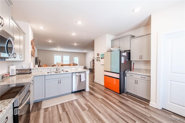 12325 Petrel Xing Unit 7, Midlothian, VA 23112 - kitchen featuring stainless steel appliances, light wood-style flooring, gray cabinetry, a peninsula, and light stone countertops