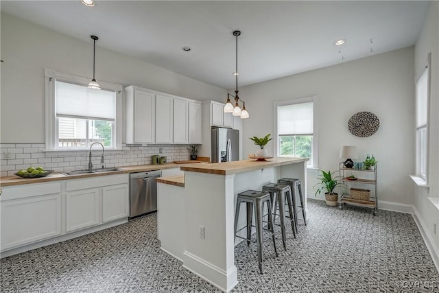 1111 N 23rd St, Richmond, VA 23223 - kitchen with wood counters, appliances with stainless steel finishes, plenty of natural light, tasteful backsplash, and recessed lighting