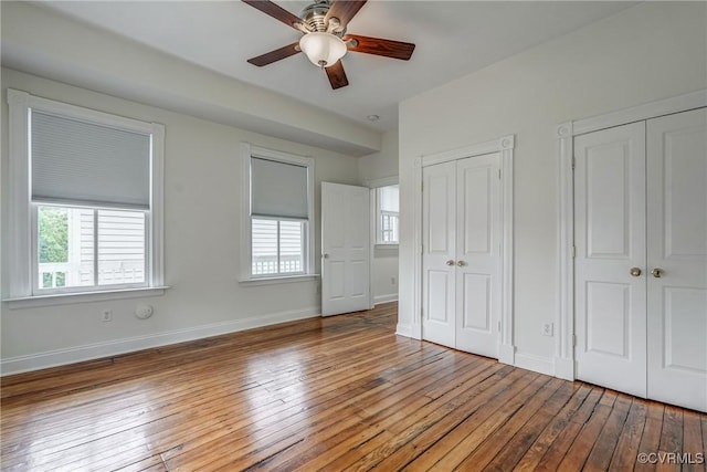 1111 N 23rd St, Richmond, VA 23223 - unfurnished bedroom featuring multiple closets, hardwood / wood-style floors, multiple windows, and ceiling fan