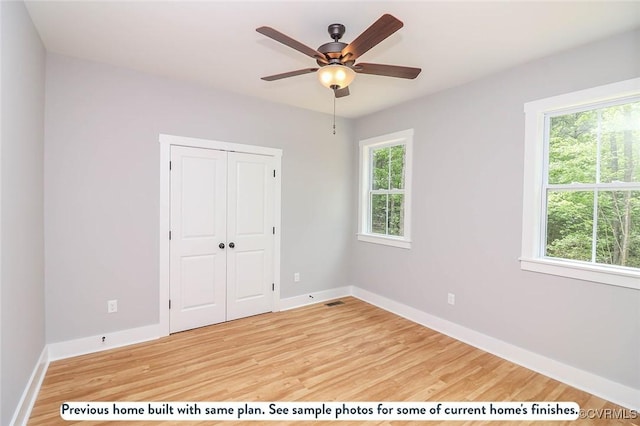 TBD Amelia Springs Road, Amelia, VA 23083 - unfurnished bedroom featuring multiple windows, light wood-style flooring, a closet, and a ceiling fan